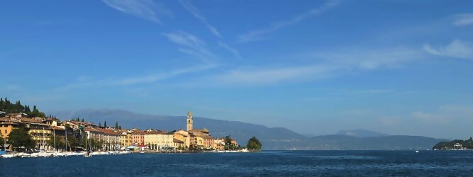 Trip El Hierro beliebte Urlaubsziele am Gardasee -  Mit einer Fläche von 370 km² ist der Gardasee der größte See Italiens. Es liegt am Fuße der Alpen und erstreckt sich über drei Staaten: Lombardei, Venetien und Trentino. Die maximale Tiefe des Sees beträgt 346 m, er hat eine längliche Form und sein nördliches Ende ist sehr schmal. Dort ist der See von den Bergen der Gruppo di Baldo umgeben. Du trittst aus deinem gemütlichen Hotelzimmer und es begrüßt dich die warme italienische Sonne. Du blickst auf den atemberaubenden Gardasee, der in zahlreichen Blautönen schimmert - von tiefem Dunkelblau bis zu funkelndem Türkis. Majestätische Berge umgeben dich, während die Brise sanft deine Haut streichelt und der Duft von blühenden Zitronenbäumen deine Nase kitzelt. Du schlenderst die malerischen, engen Gassen entlang, vorbei an farbenfrohen, blumengeschmückten Häusern. Vereinzelt unterbricht das fröhliche Lachen der Einheimischen die friedvolle Stille. Du fühlst dich wie in einem Traum, der nicht enden will. Jeder Schritt führt dich zu neuen Entdeckungen und Abenteuern. Du probierst die köstliche italienische Küche mit ihren frischen Zutaten und verführerischen Aromen. Die Sonne geht langsam unter und taucht den Himmel in ein leuchtendes Orange-rot - ein spektakulärer Anblick.